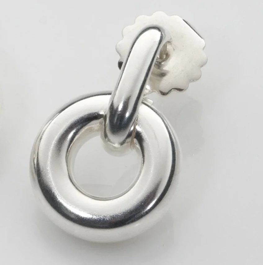 Close-up of Monad Link earrings showing thick 5mm wire torus form in sterling silver