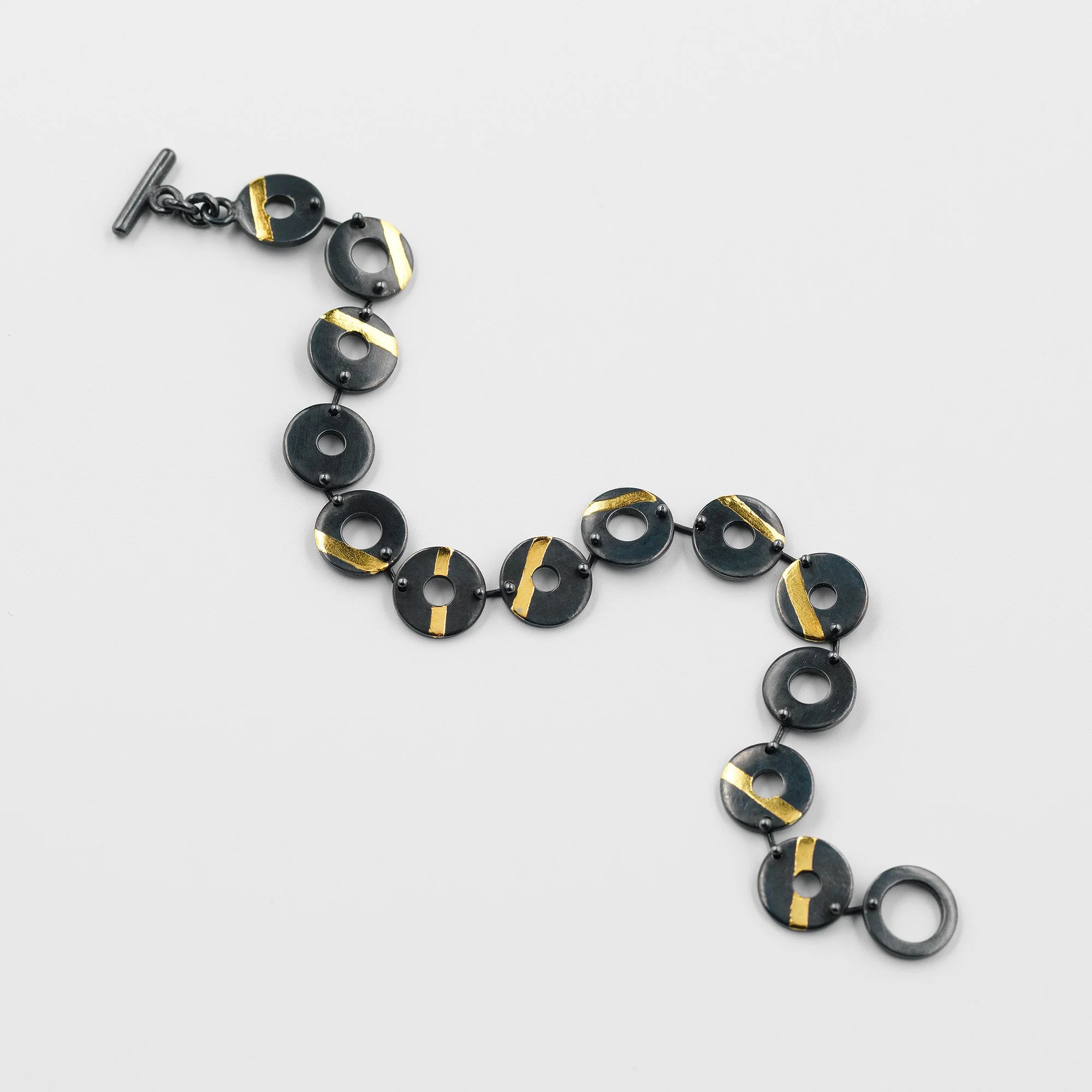 Oxidised sterling silver Chronos bracelet, linked flat torus shapes with 24ct gold stripes
