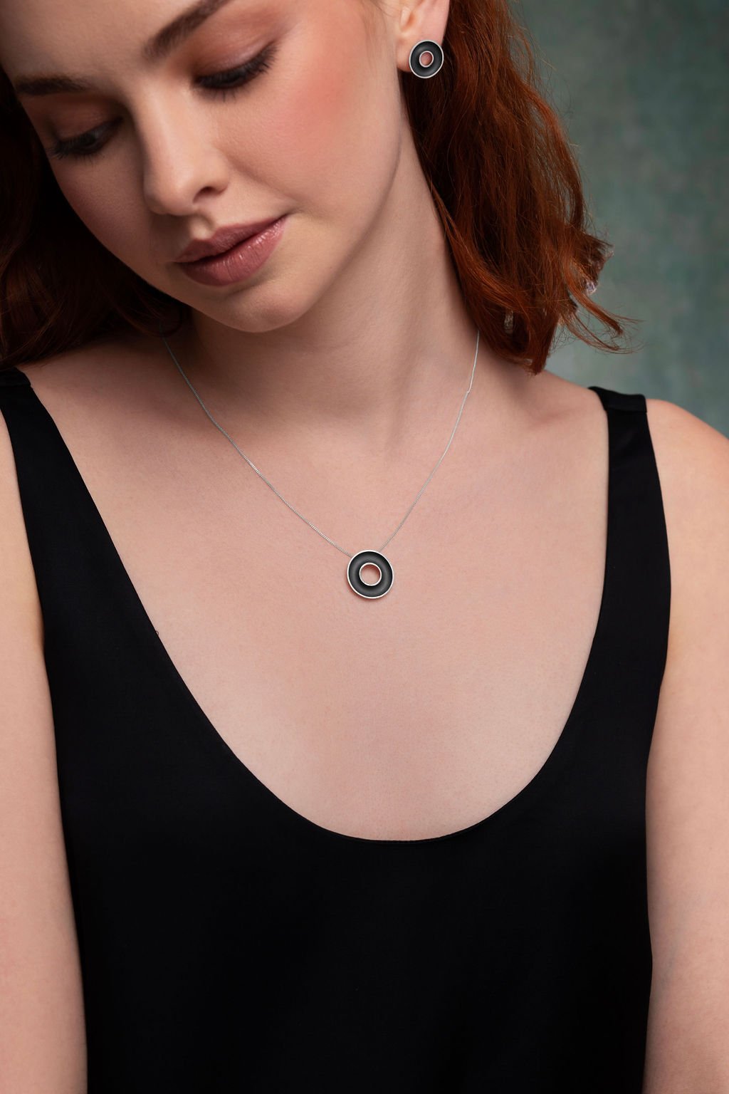 Model wearing sterling silver Orbis necklace and earrings with concave torus form