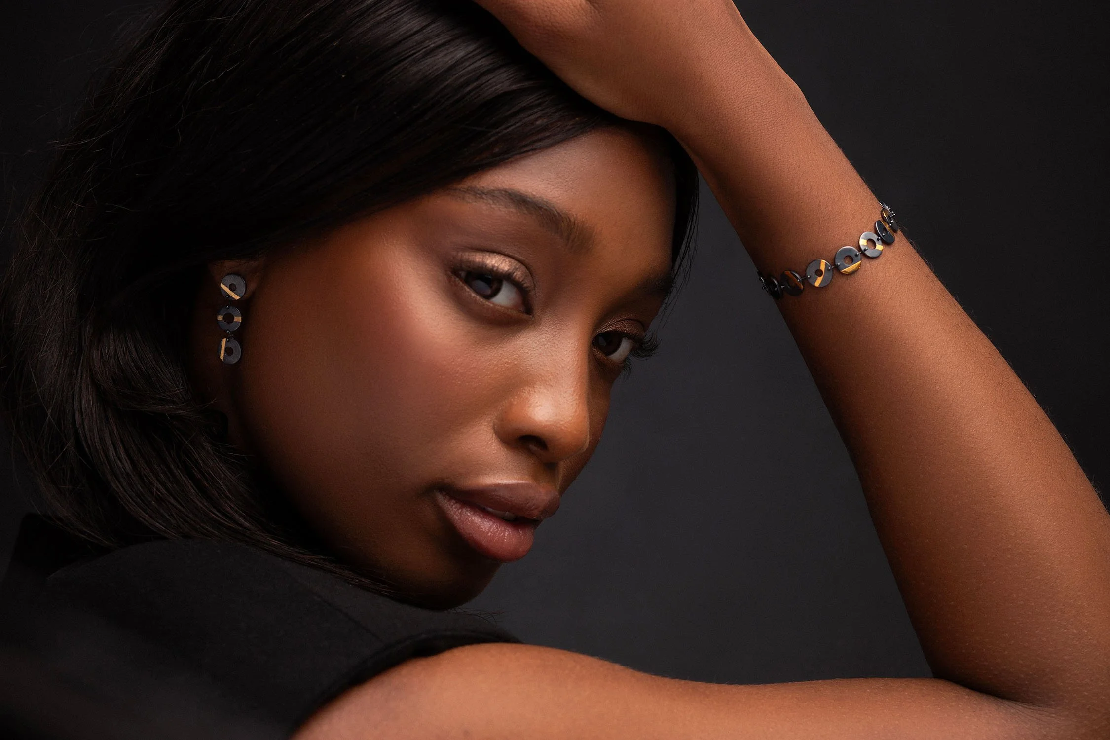 Model wearing oxidised sterling silver Chronos earrings and bracelet with 24ct gold stripe detailing