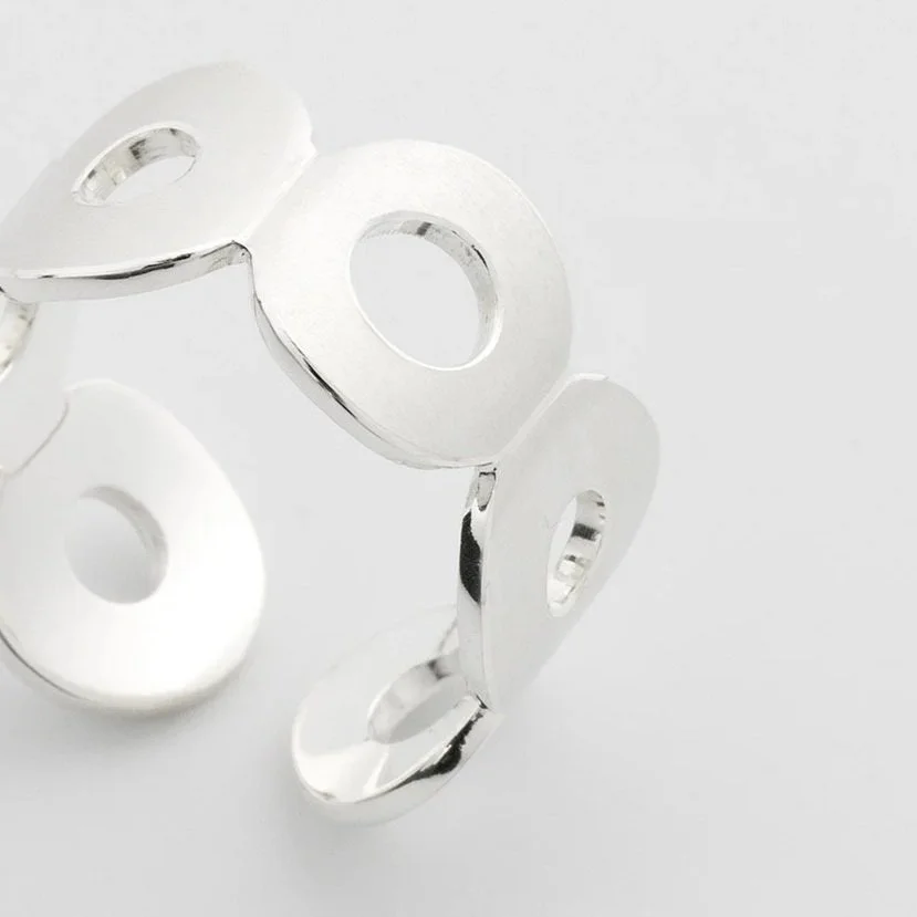 Close-up of Kairoi Undone ring showing connected flat torus forms in sterling silver