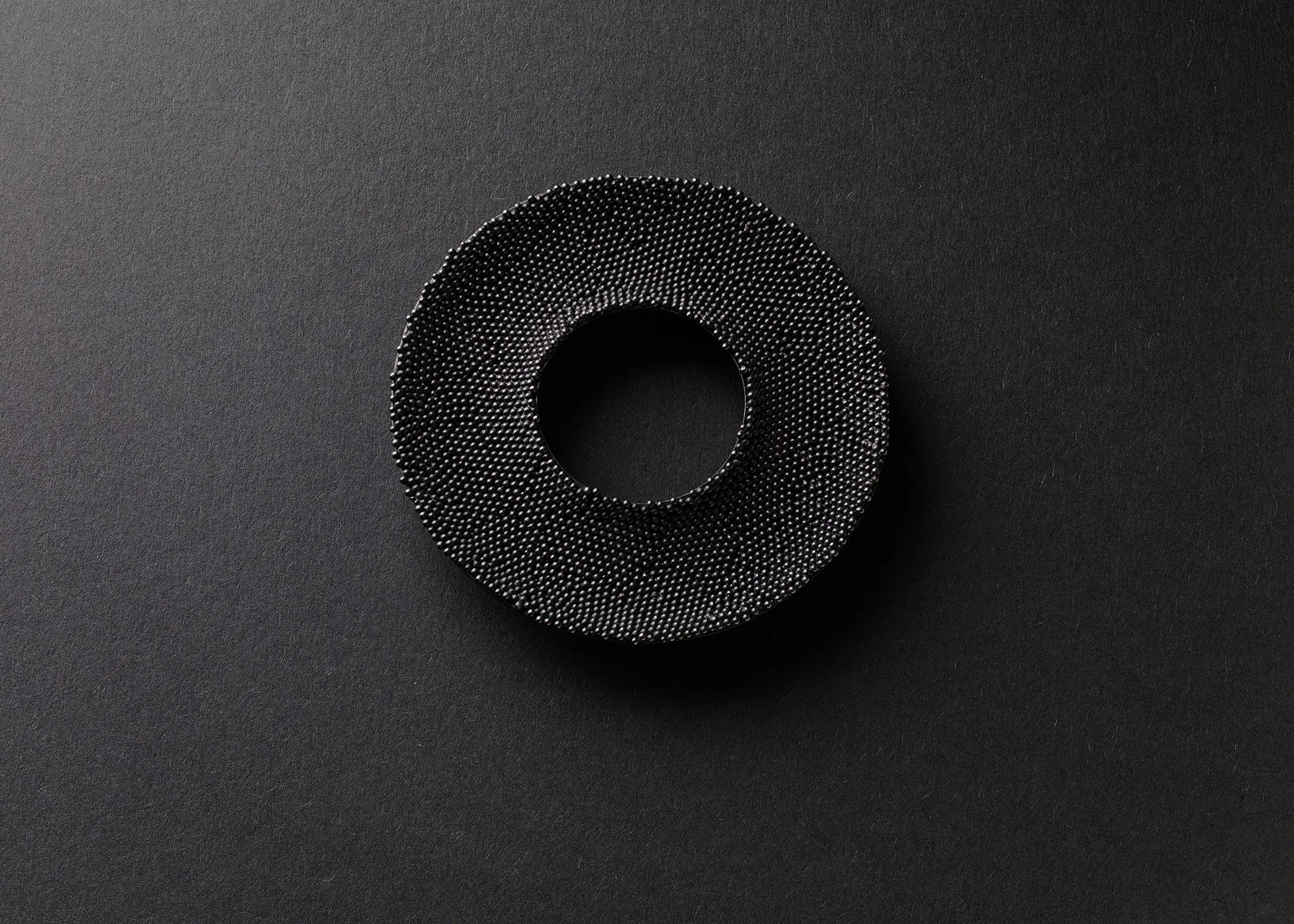 Over and Over Brooch in oxidised sterling silver with surface covered in hundreds of tiny silver granules