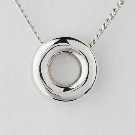 Close-up of Monad mini necklace showing small polished torus pendant in sterling silver