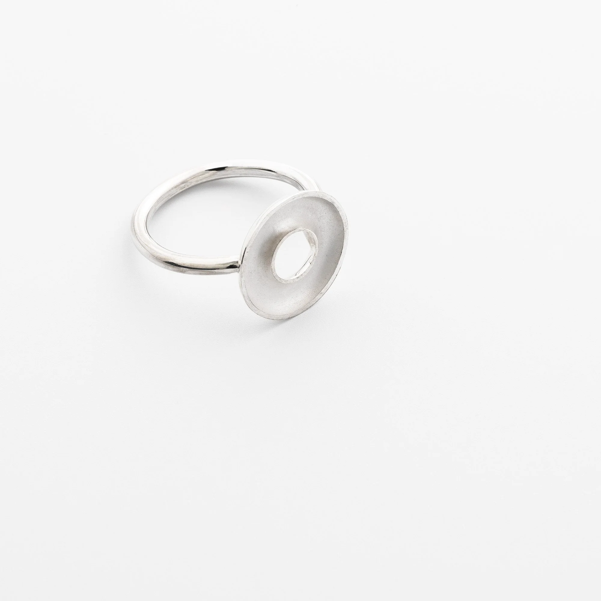 Sterling silver Orbis small ring, circular concave torus mounted on round band, polished edge and white interior