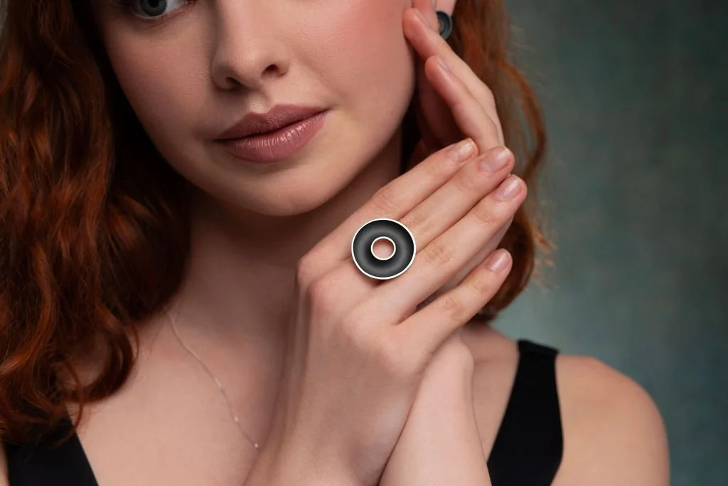 Model wearing large Orbis ring in oxidised sterling silver with polished edges.