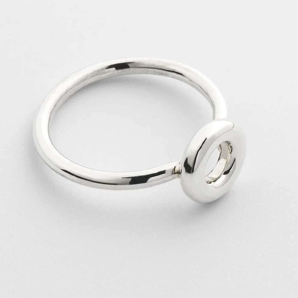 Close-up of Monad ring showing polished circular torus form and round band in sterling silver