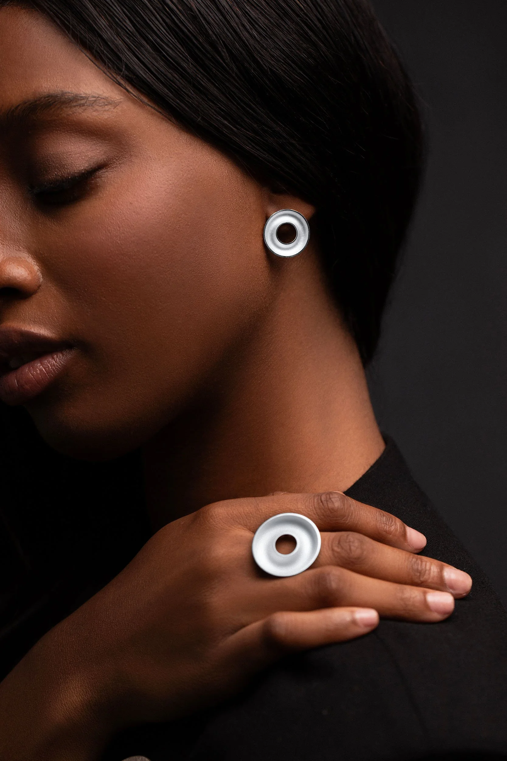 Hand wearing sterling silver Orbis large ring, concave torus form, white interior