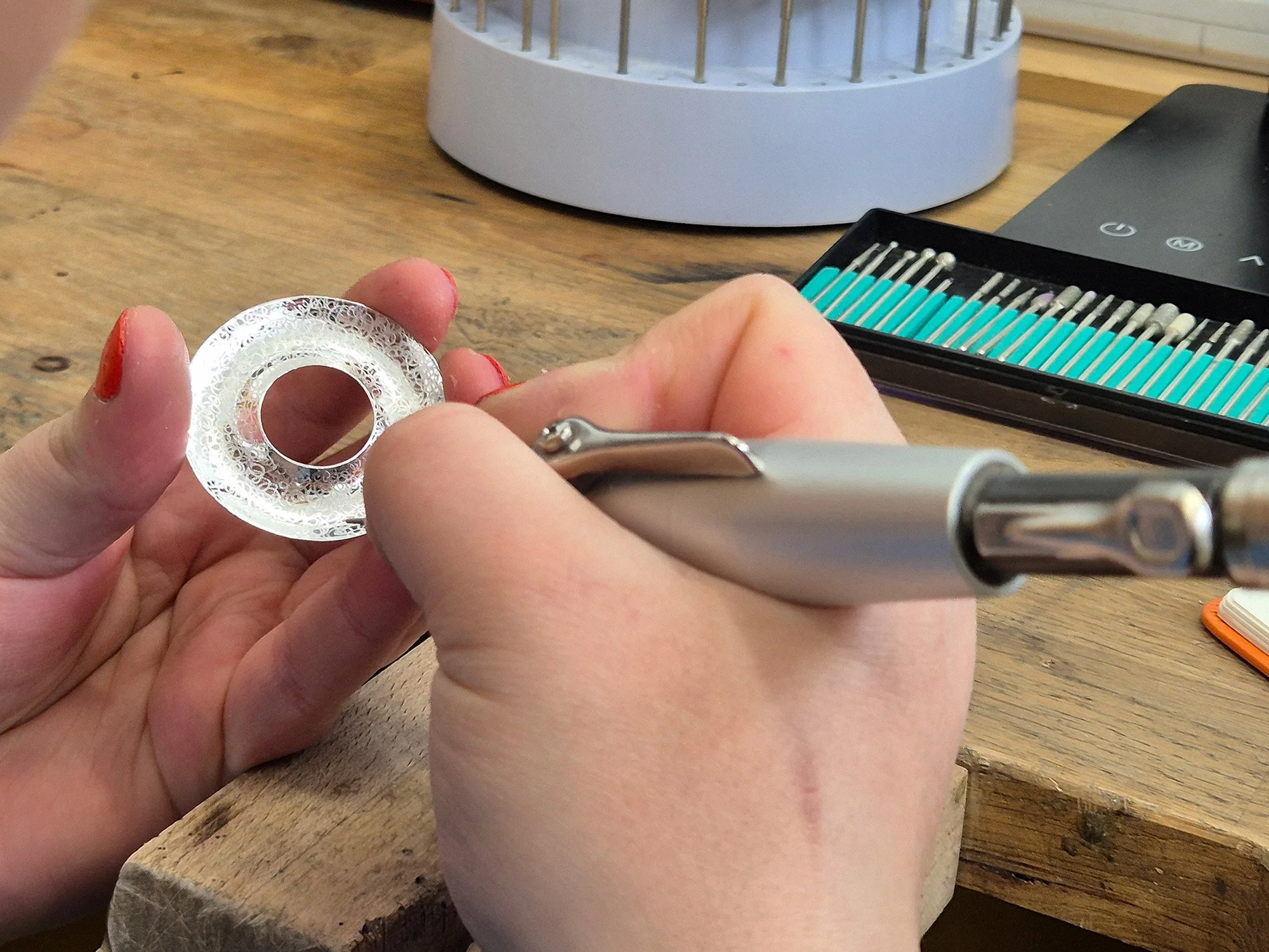 Texturing a torus form at the jeweller’s bench during the making process.