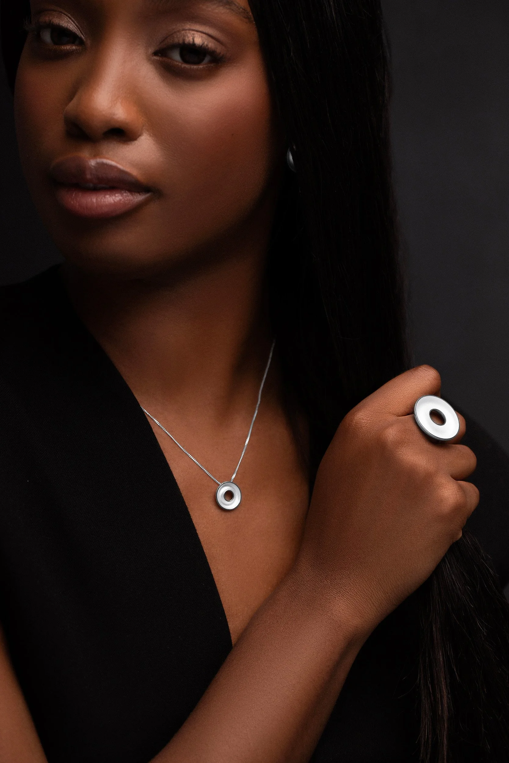 Model wearing sterling silver Orbis small necklace, circular, concave torus pendant