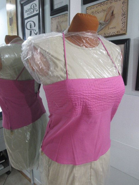 Pink sleeveless top on a dress form mannequin.