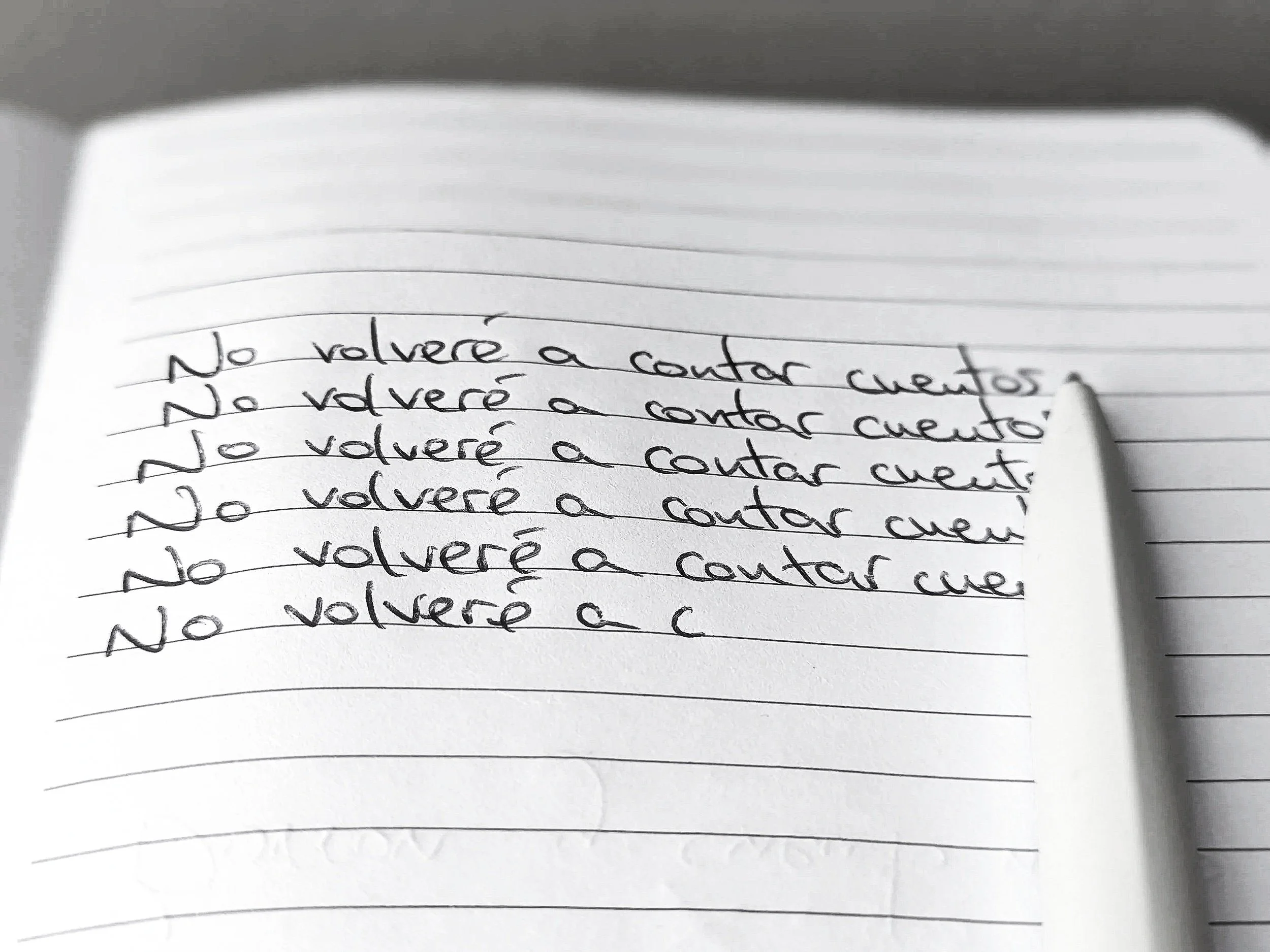 Foto de un cuaderno con la frase repetida "No volveré a contar cuentos"