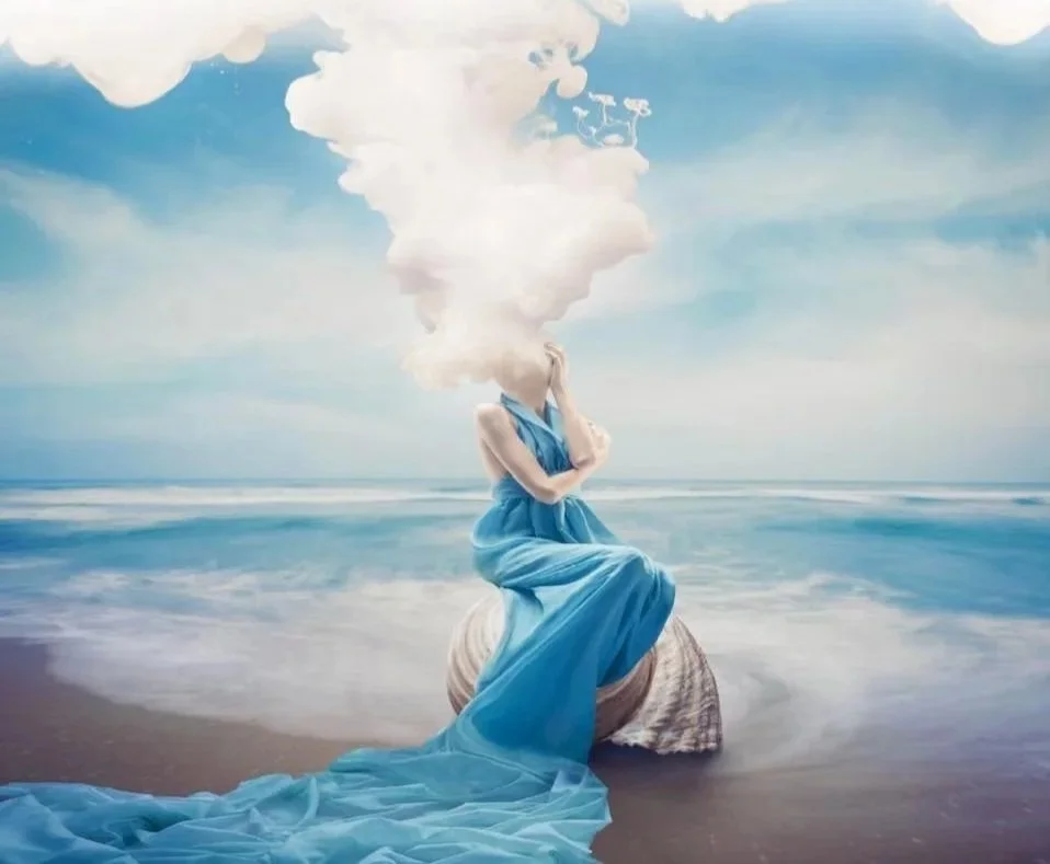 A surreal artwork of a woman in a blue dress sitting on a large seashell at the beach, with her head replaced by a cloud of smoke or mist that blends into the sky.