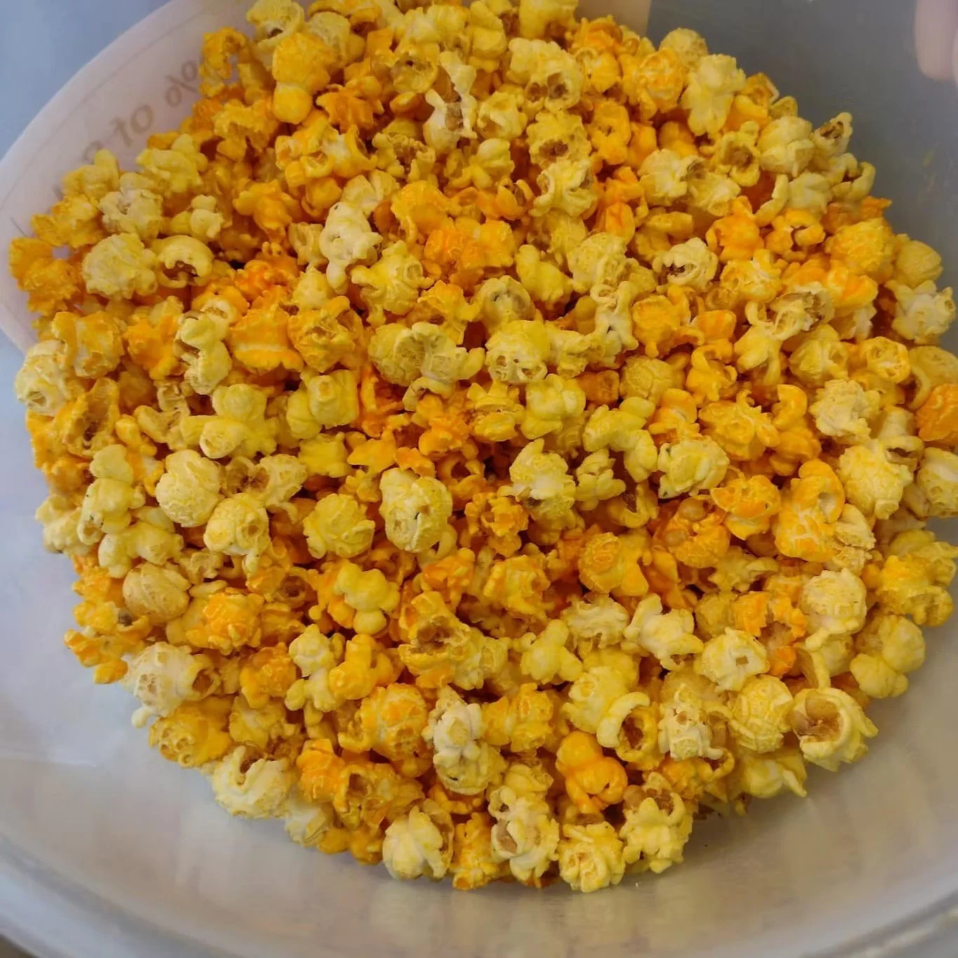 A bowl filled with yellow and white popcorn.