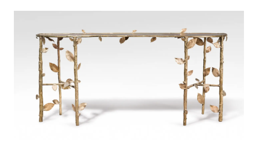 A wooden table with leaf-like designs on the sides and legs, decorated with wooden leaves attached to the structure.