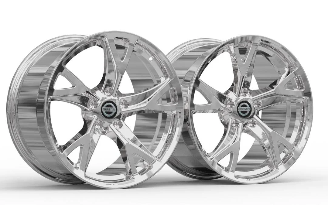 Two shiny chrome Nissan car wheels with intricate, modern spoke designs.