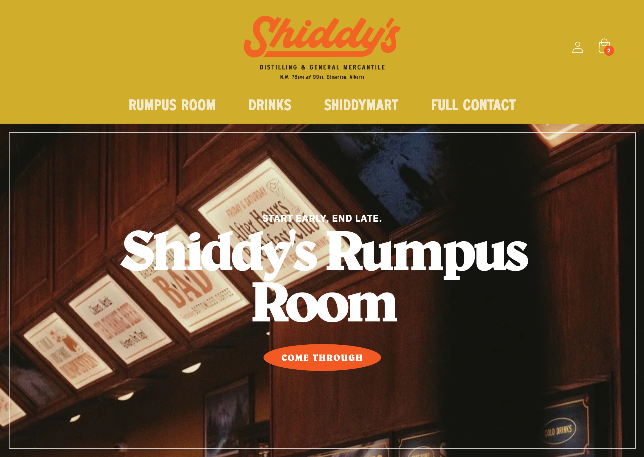 Website homepage for Shiddy's Rumpus Room with a header menu including options for Rumpus Room, Drinks, Shiddymart, and Full Contact. The background features wooden paneling and illuminated signs for the venue, with a prominent call-to-action button labeled "Come Through."