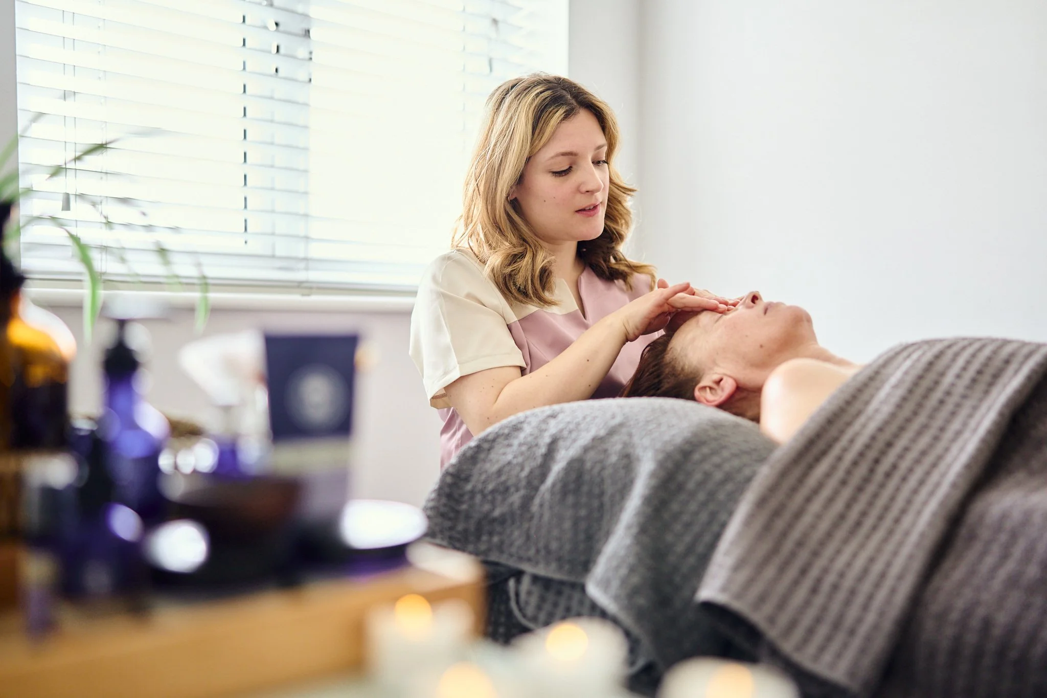 Massage therapist Gabriella Bloom providing a relaxing facial massage in her serene home spa setup in Fleet, Hampshire.