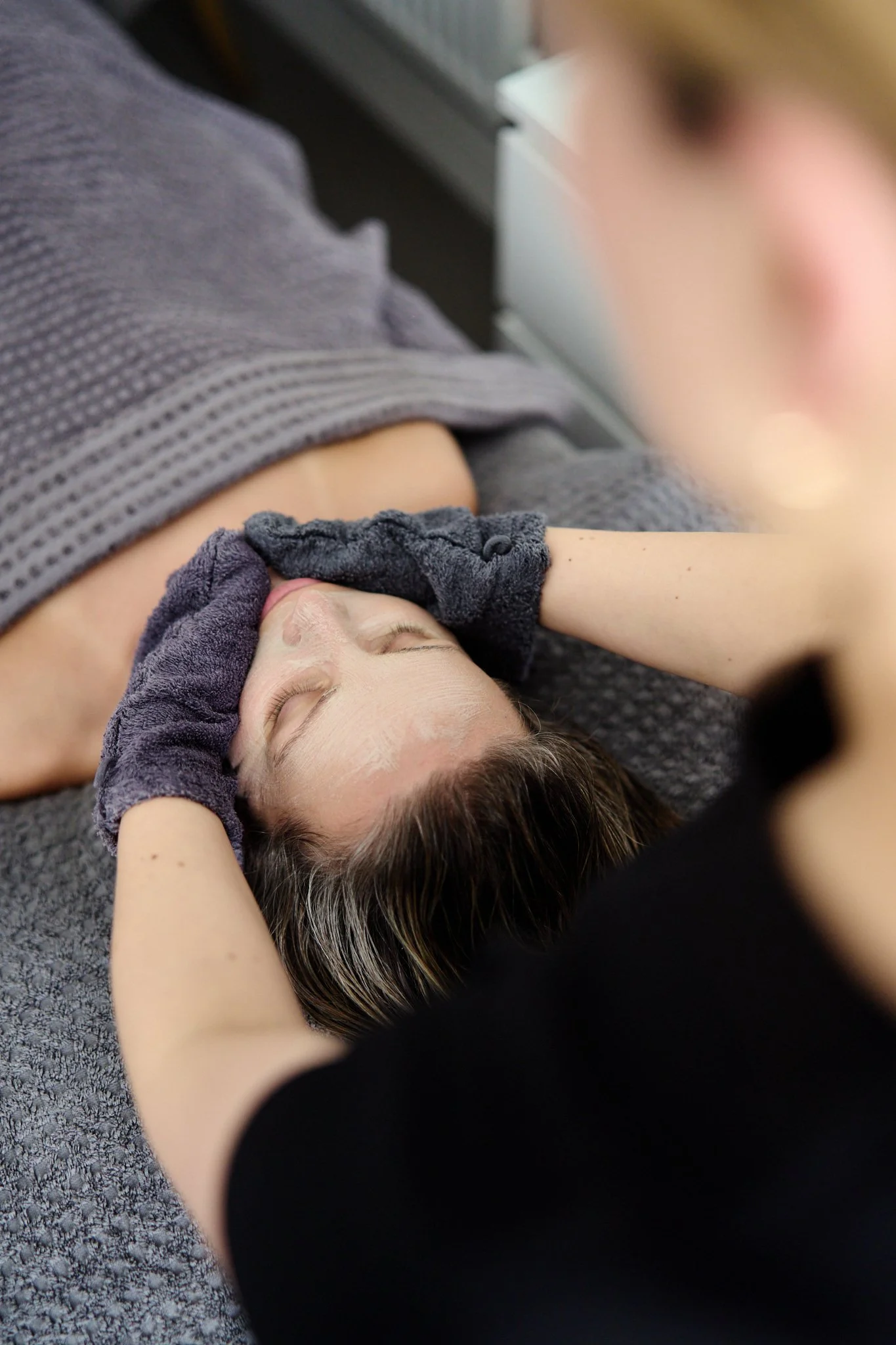 Massage therapist Gabriella Bloom providing a relaxing facial massage in her serene home spa setup in Fleet, Hampshire.