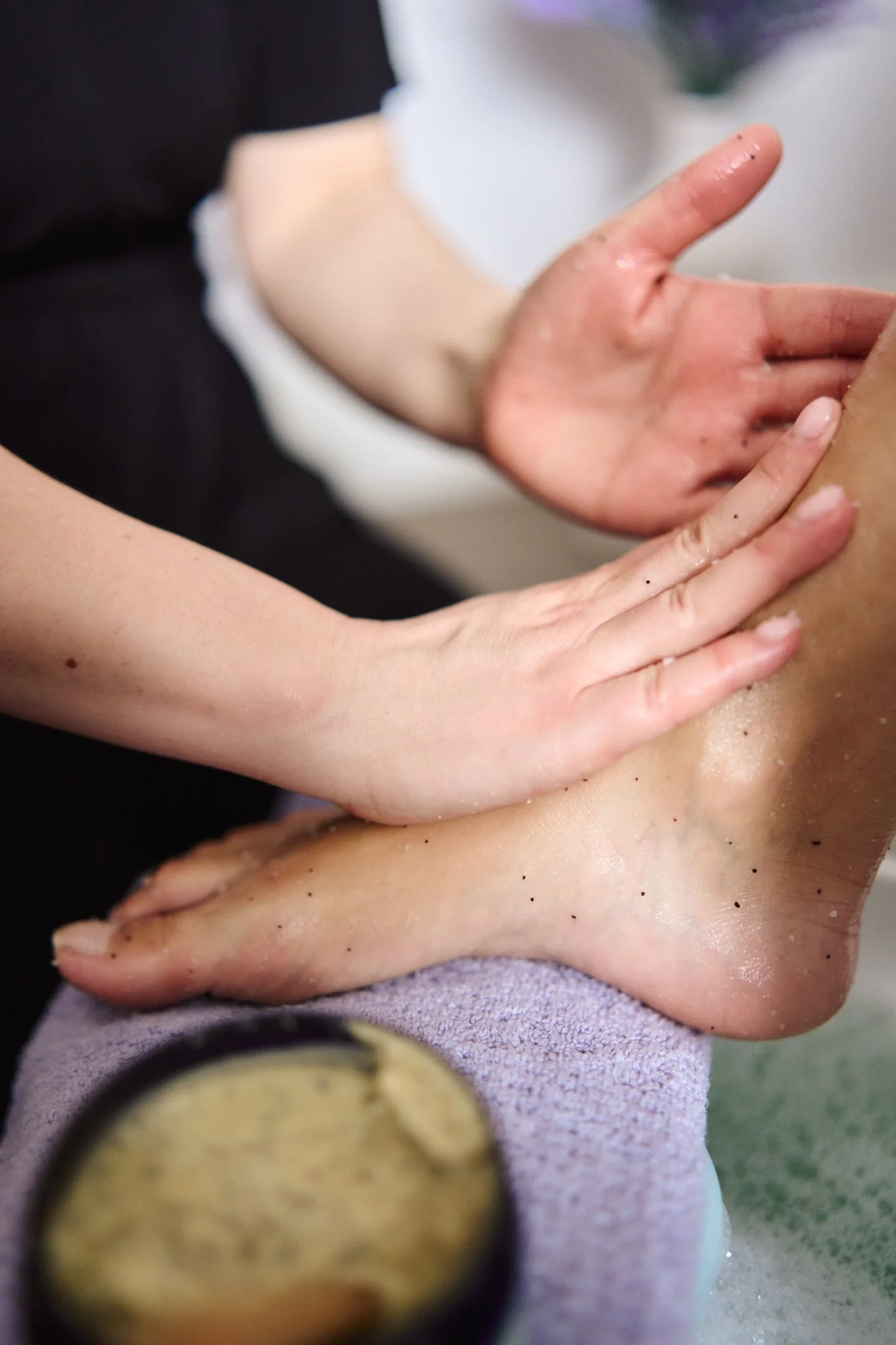 Experienced therapist Gabriella Bloom carefully scrubbing the client's feet with high quality products in Fleet, Hampshire