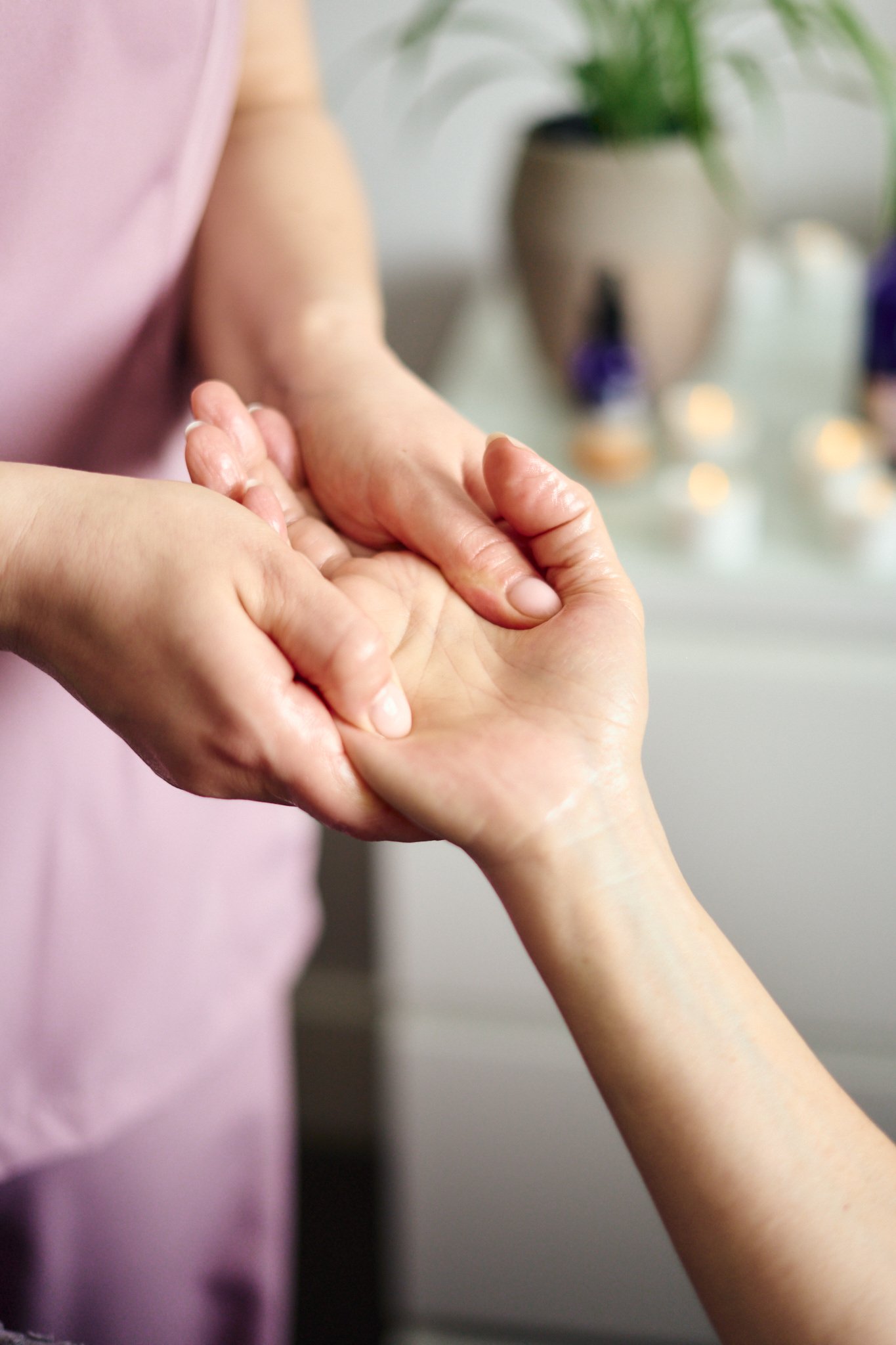Skilled massage therapist Gabriella Bloom squeezing the tension out of a client's hand as she gives a relaxing massage in Fleet, Hampshire.
