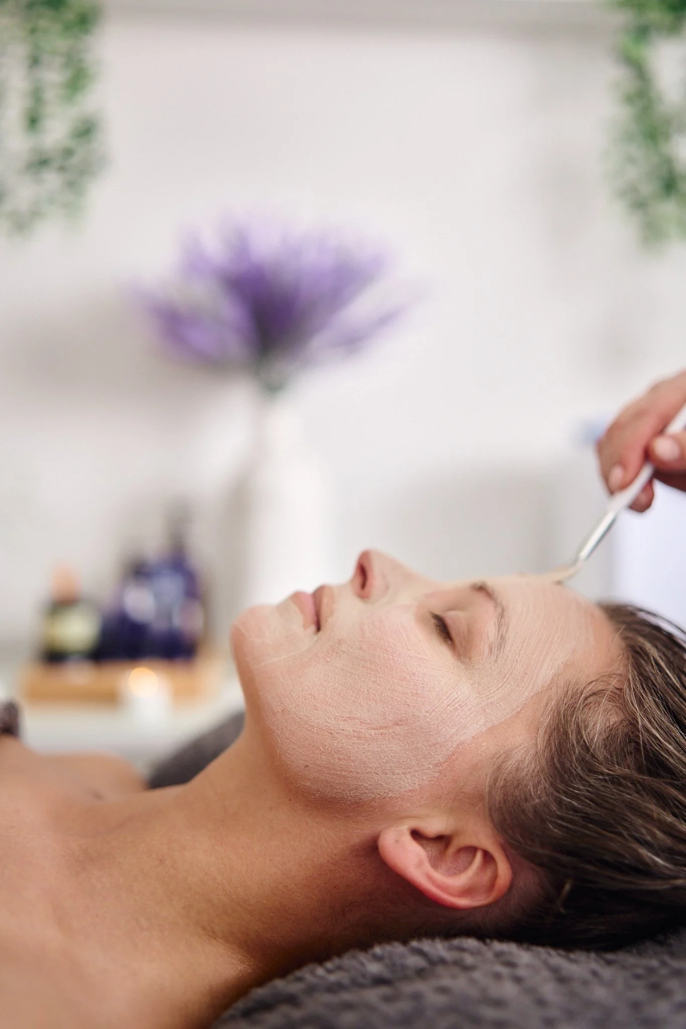Massage therapist Gabriella Bloom providing a relaxing facial massage in her serene home spa setup in Fleet, Hampshire.