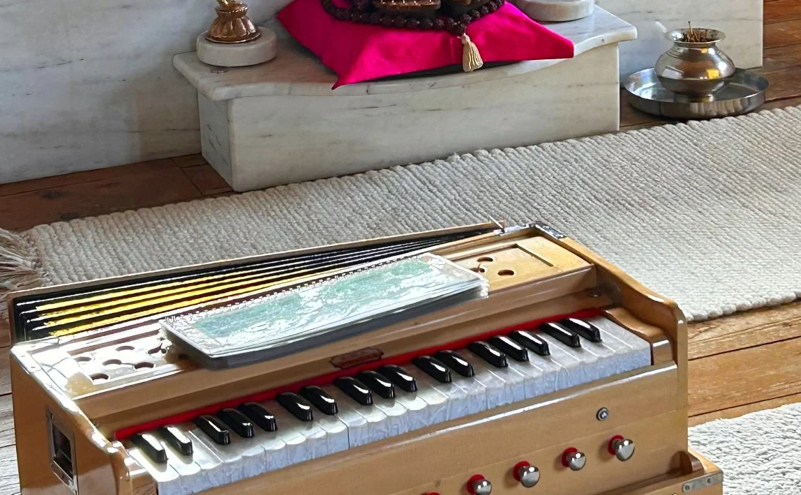 Holzspielzeugpiano mit schwarzen und weißen Tasten, auf dem ein Notenblatt liegt, auf einem Holzboden neben einem Teppich.