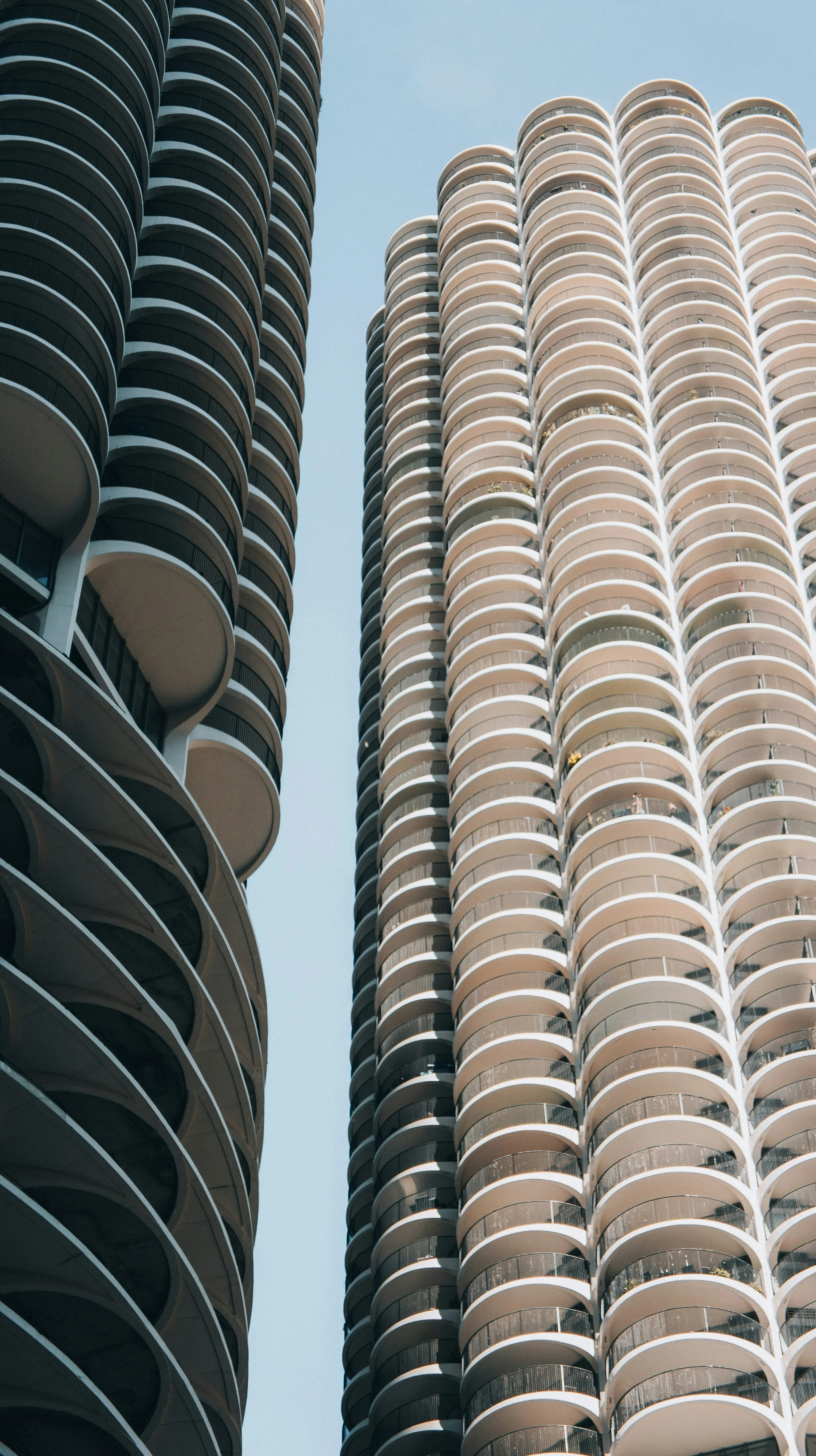 Three tall modern skyscrapers in Chicago with curved balconies, viewed from below against a clear sky.