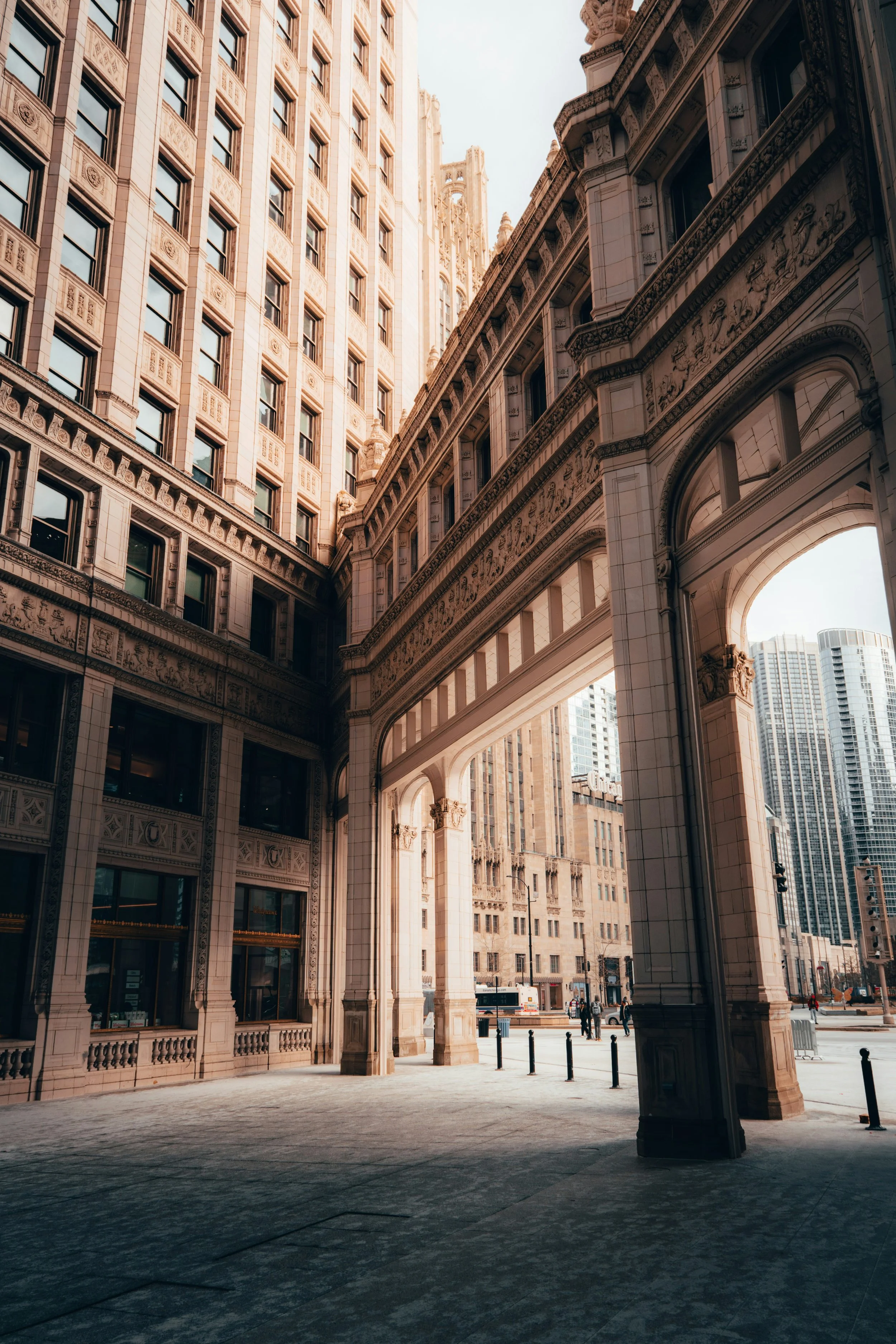 View of tall historic buildings in Chicago with ornate architecture in an urban city, with an archway and street scene below.