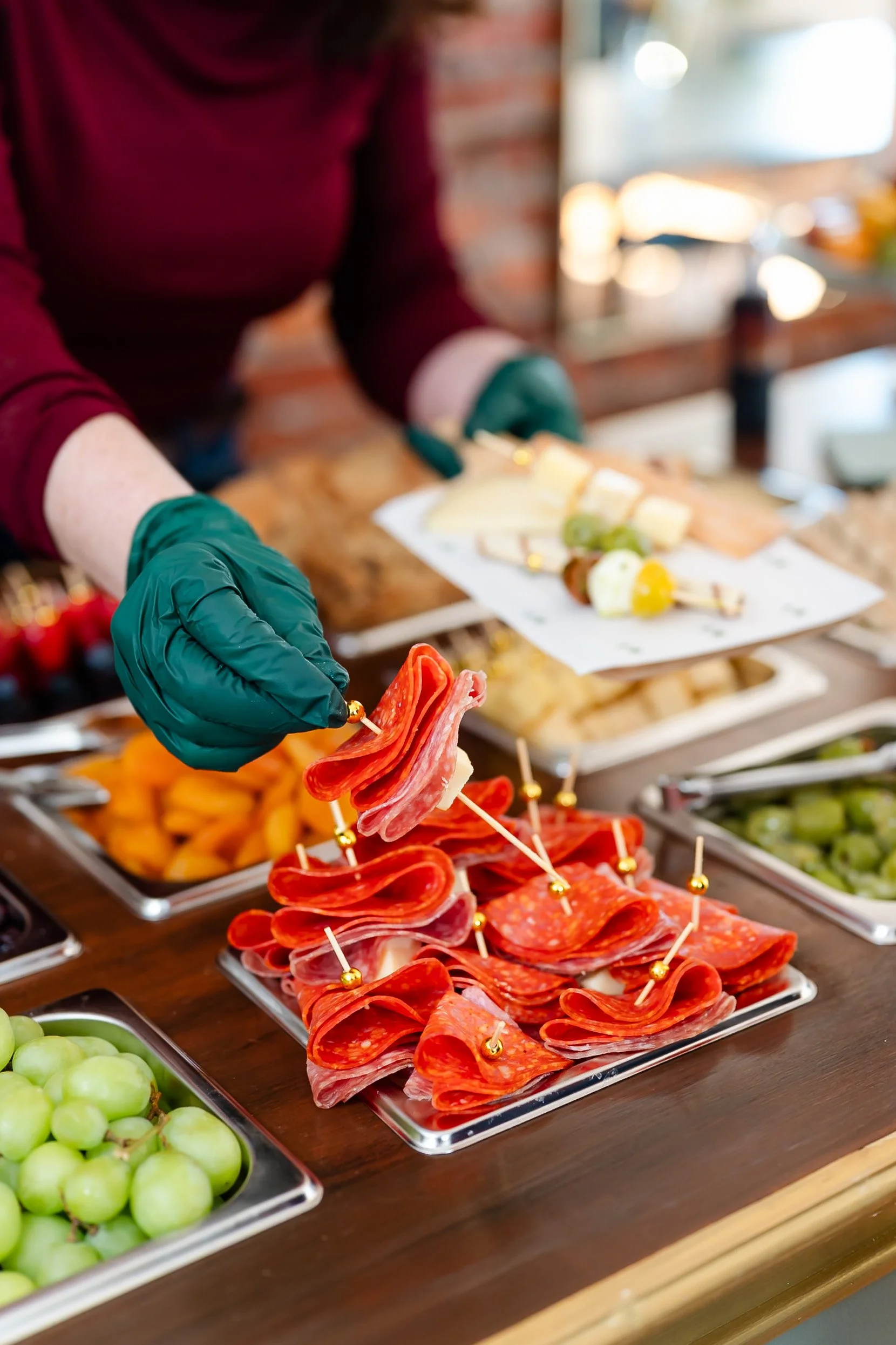 Hand selecting charcuterie items from display