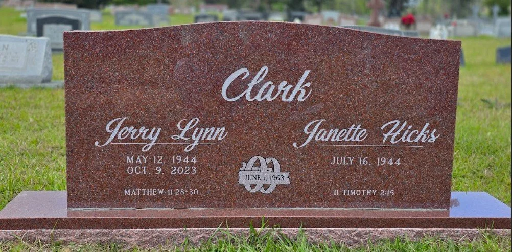 Granite headstone in a cemetery with the inscriptions of Clark, Jerry Lynn, and Janette Hicks, including birth and death dates, Bible references, and a decorative symbol with June 1, 1963.
