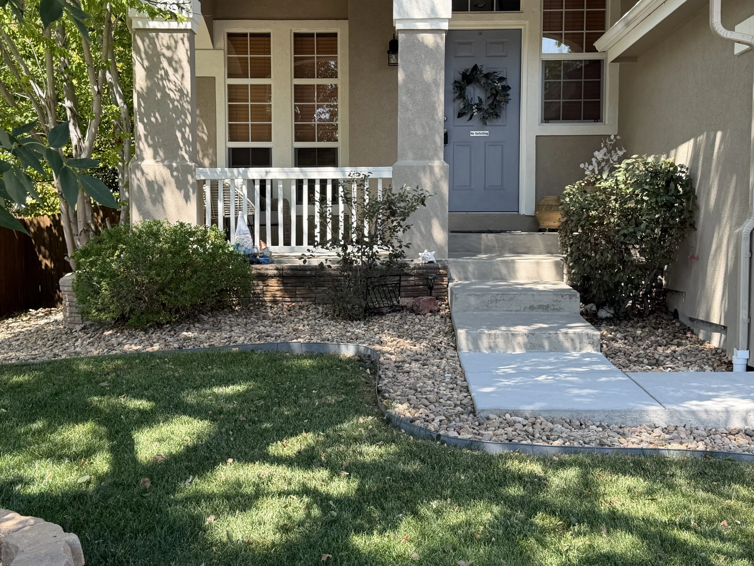 After: Overgrown shrubs were trimmed and shaped to improve curb appeal, open the walkways, and give the landscape a cleaner, more maintained appearance.