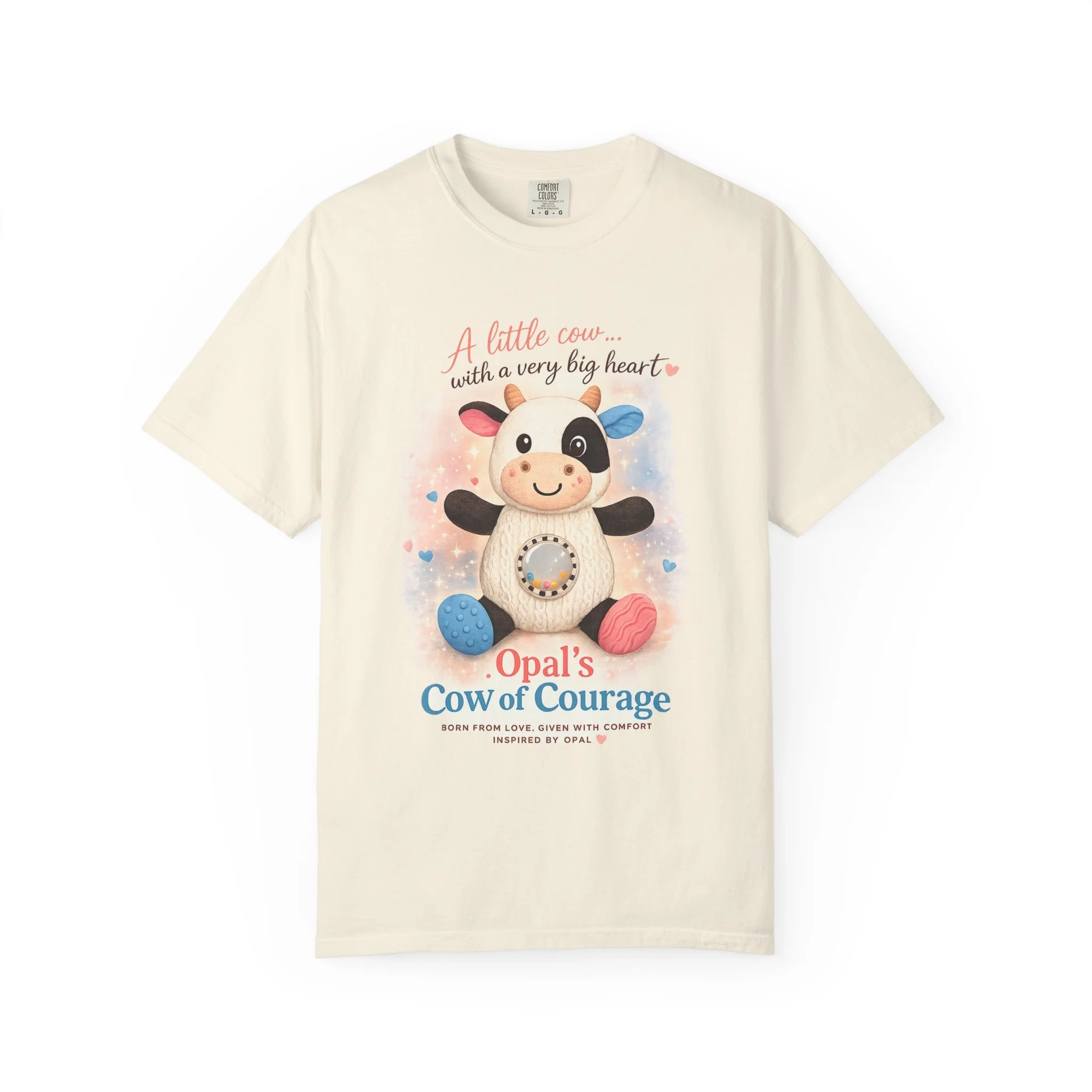 This soft, garment-dyed tee carries a gentle, heartfelt design that reads like a tiny wearable story. Front artwork shows a plush cow with pastel accents and the phrase “A little cow… with a very big heart,” while the back lists a tender message fram