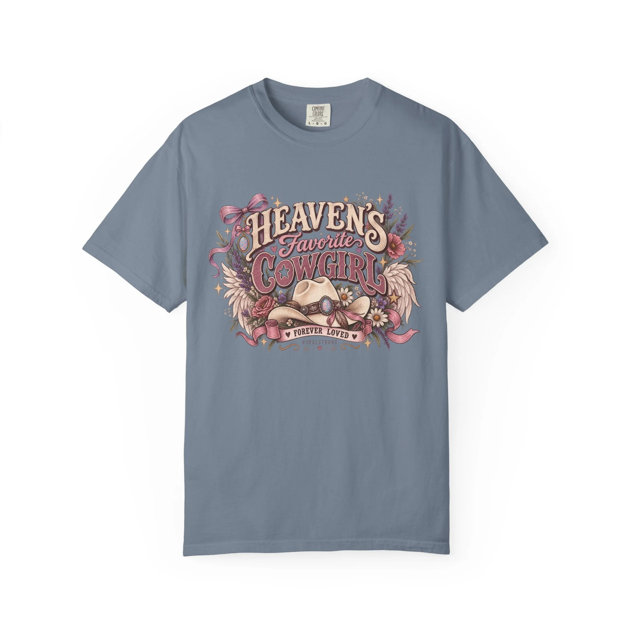 Soft, lived-in, and full of gentle country charm — this garment-dyed tee wears like an old favorite from the first touch. A vintage-inspired Western illustration rests across the chest: a worn cowboy hat, wildflowers, and flowing ribbon lettering tha