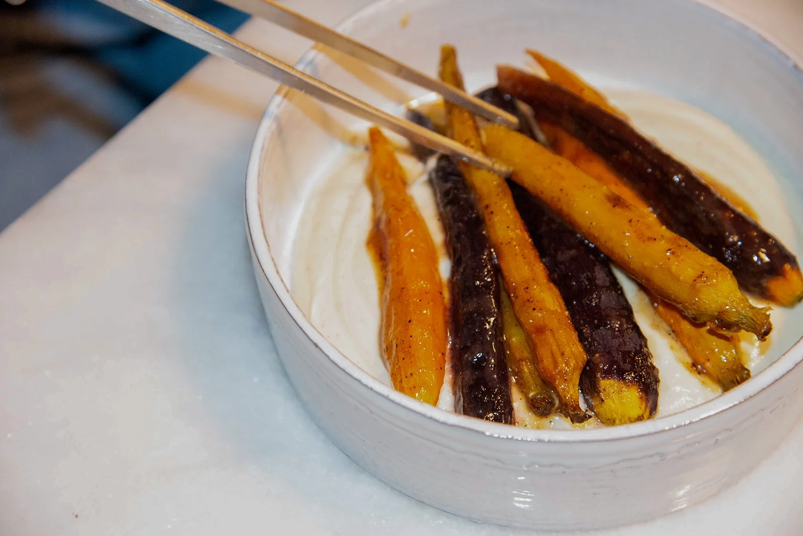 Roasted carrots in various colors served on a white plate.