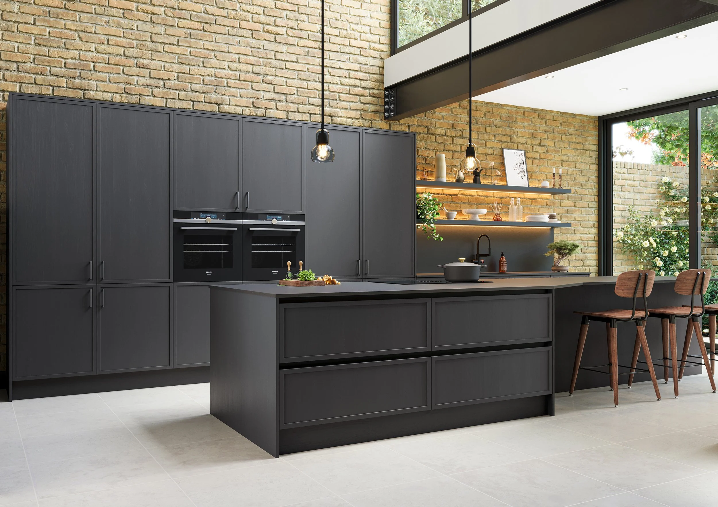 Modern kitchen with dark gray cabinetry, a kitchen island, two hanging pendant lights, and large windows showing greenery outside.