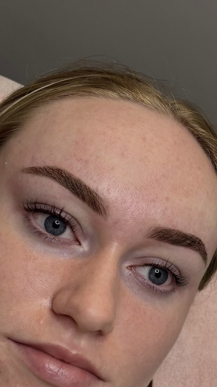 Close-up of a woman's face showing her eyebrows, blue eyes, and part of her forehead and cheeks.