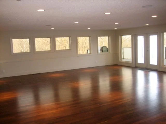 McKenzie Lake Beach Club studio area in Calgary with large windows, hardwood floors, and glass doors leading outside.