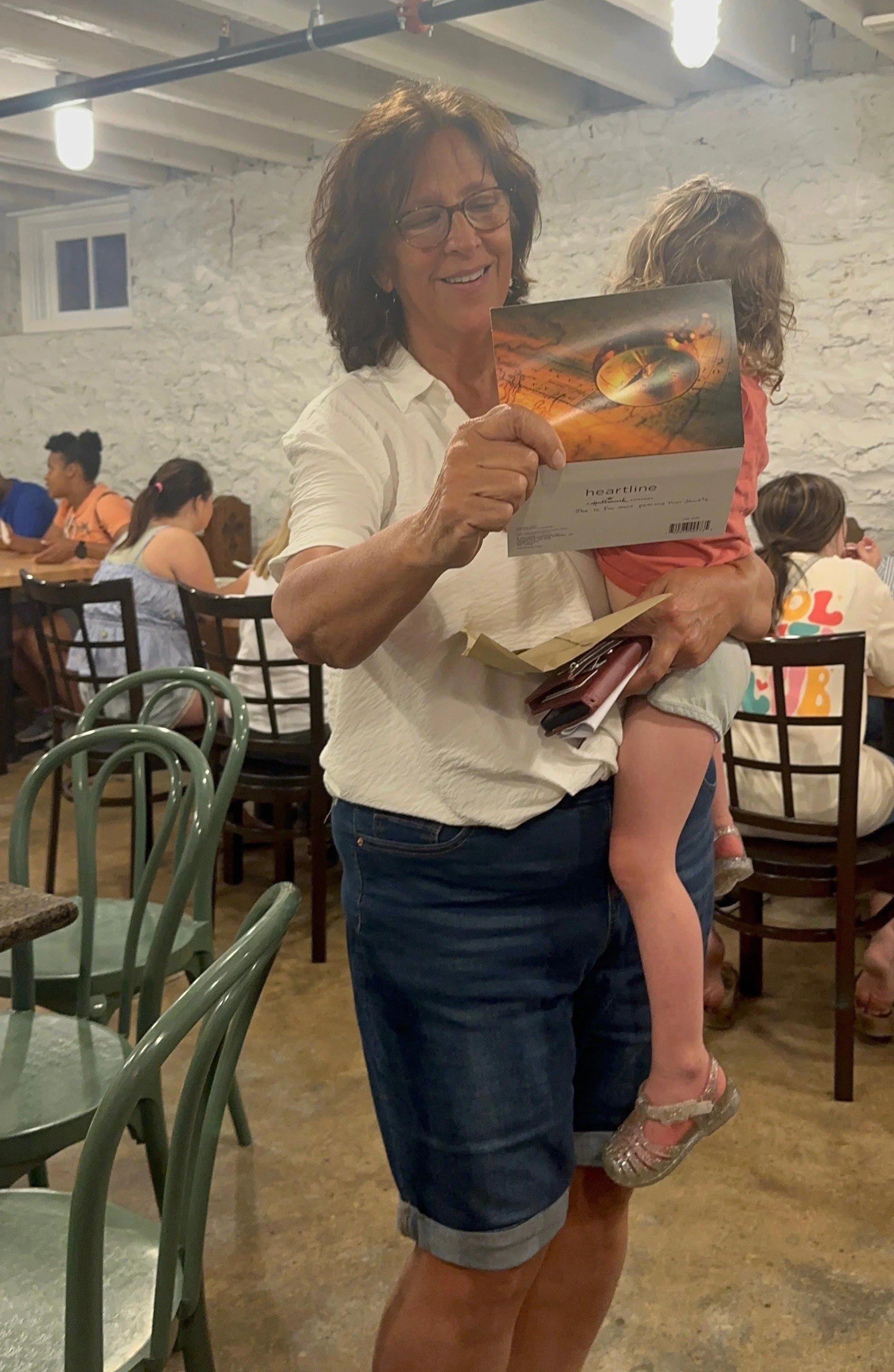 Cindy holds her grandchild while trying to figure out a last clue to what the surprise is- she doesn't know it's her Grandmas ring