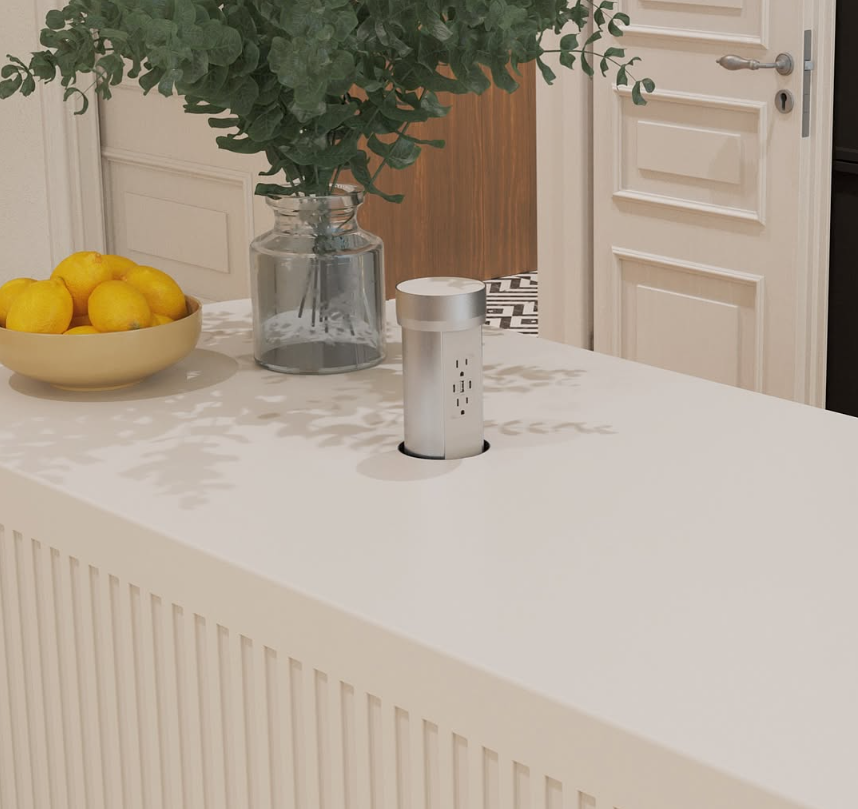 A kitchen countertop with a bowl of lemons, a glass jar with green leafy plant, and a smart speaker or home assistant device.