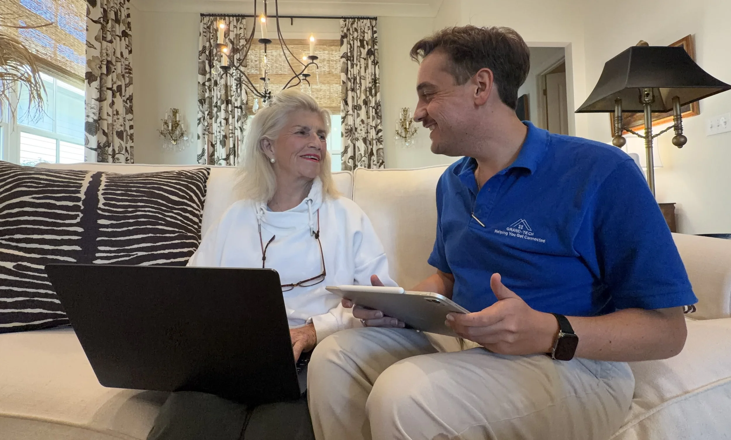 Patrick Wink of Grand-Tech helping a client with her laptop at home.