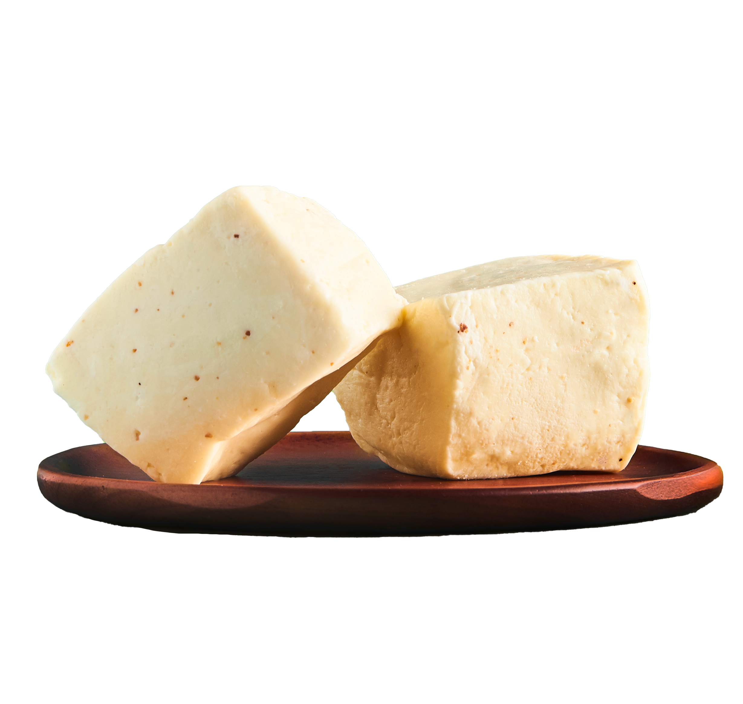 Close-up image of two blocks of Kasbo's Middle Eastern Kitchen's jibneh, Syrian cheese on a round wooden serving board.