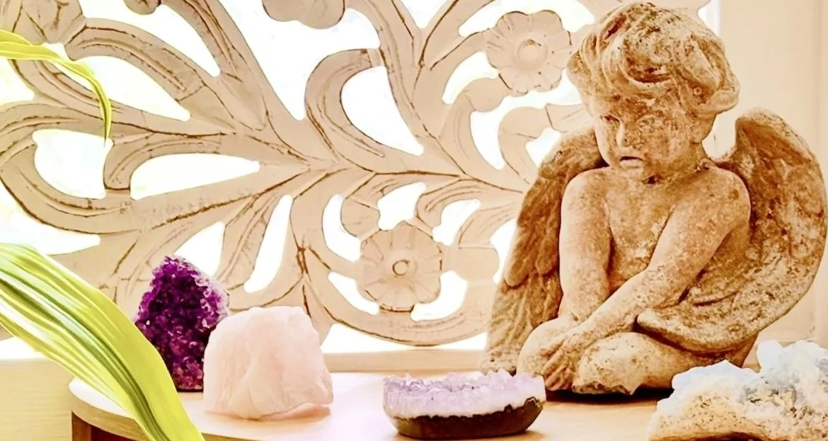 A cherub angel kneeling beside healing crystals at Catherine Goodman's studio in Sausalito, CA.