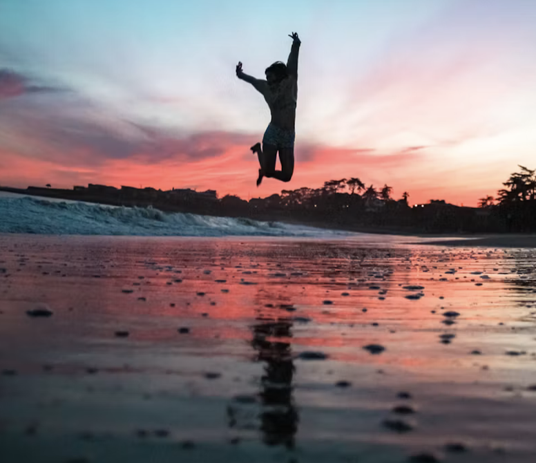 A man jumping in the air over water