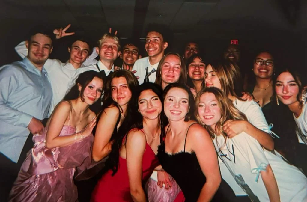 Group of young people at a celebration or party, smiling and posing for the camera.