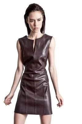 A woman with dark hair wearing a sleeveless, dark brown leather dress looking down with a serious expression.