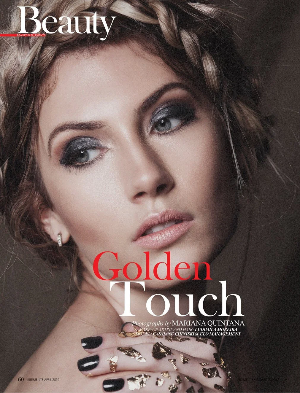 Close-up of a woman with styled hair, wearing makeup including dark eyeshadow and nude lipstick, with her hand near her face showing black nail polish and gold leaf accents. Magazine cover with the titles "Beauty" and "Golden Touch."