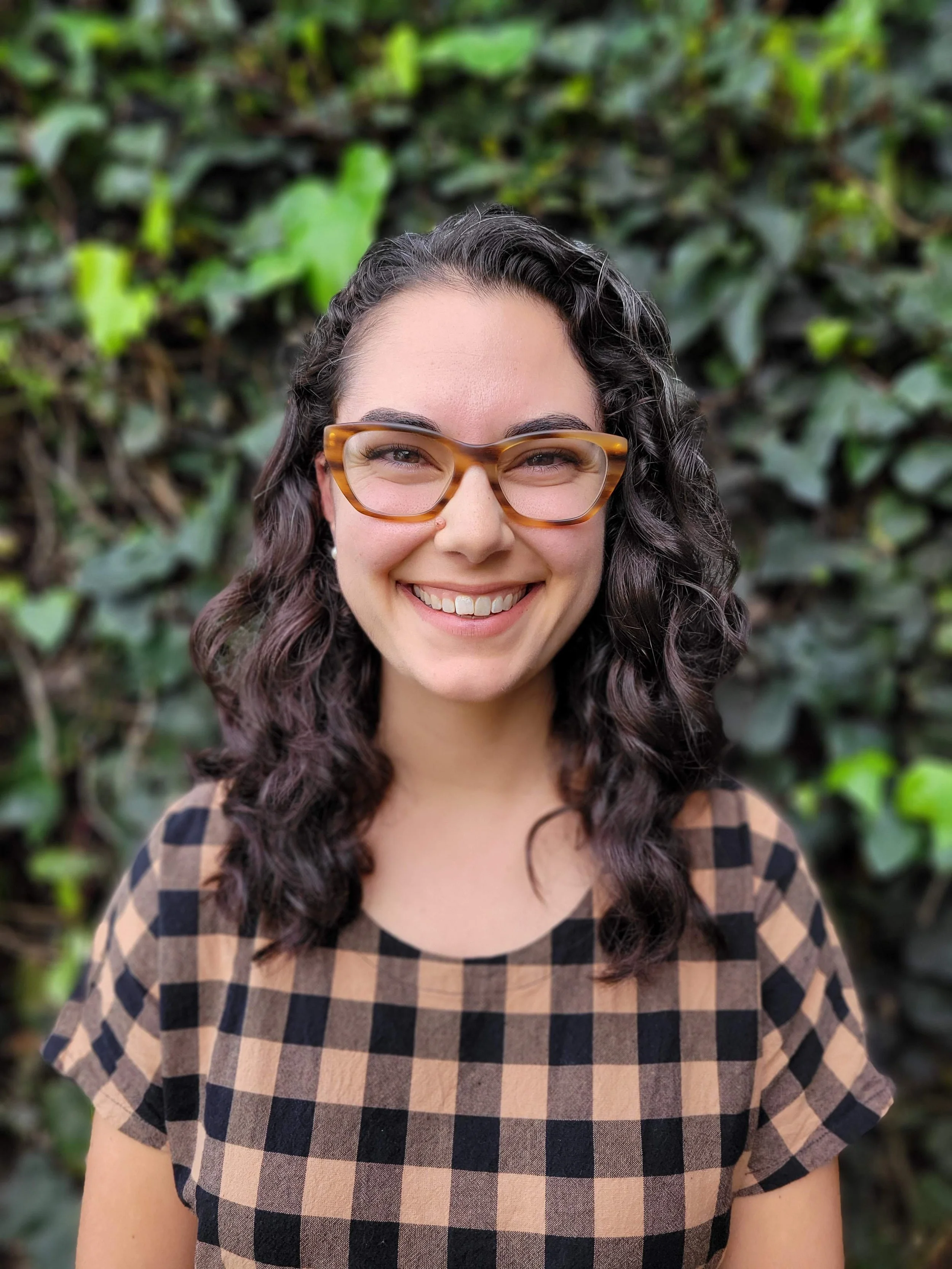 Headshot of Katie Lowe, smiling and wearing glasses.