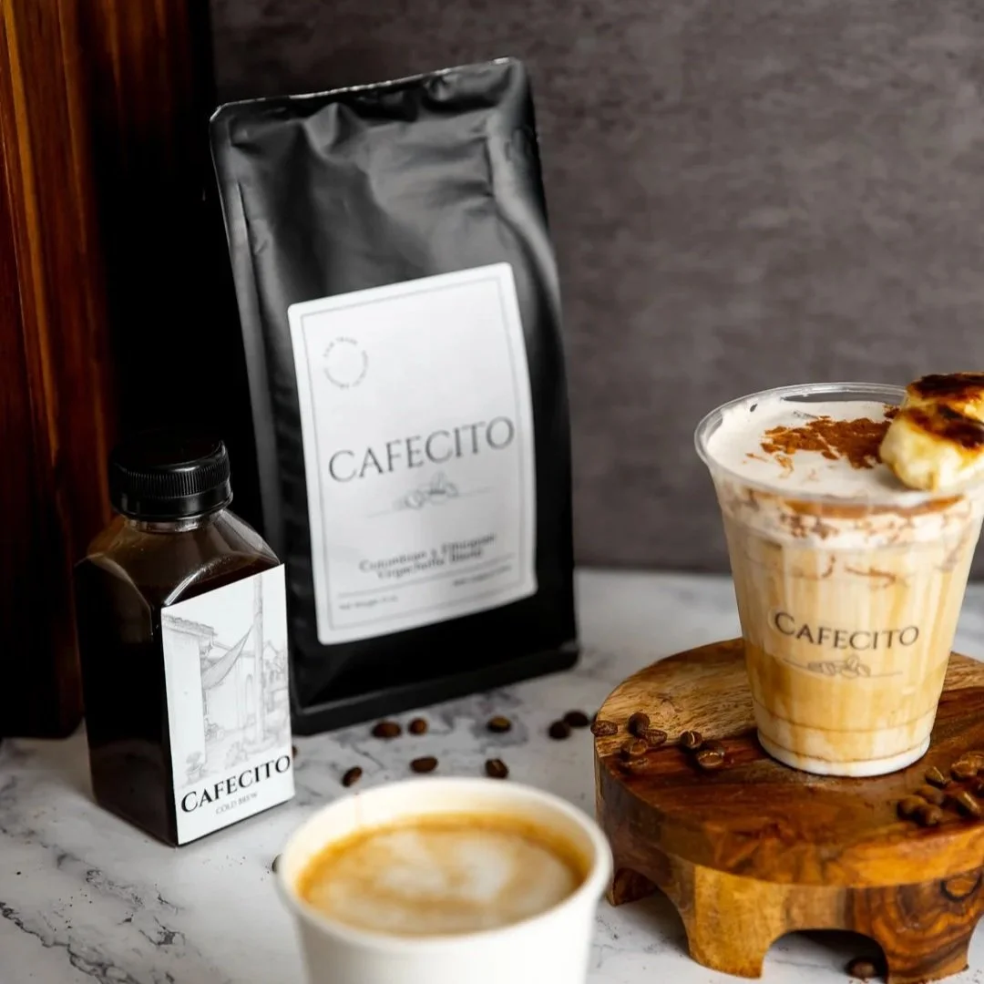 Coffee drinks with coffee beans, coffee bag, and bottled cold brew on marble surface.