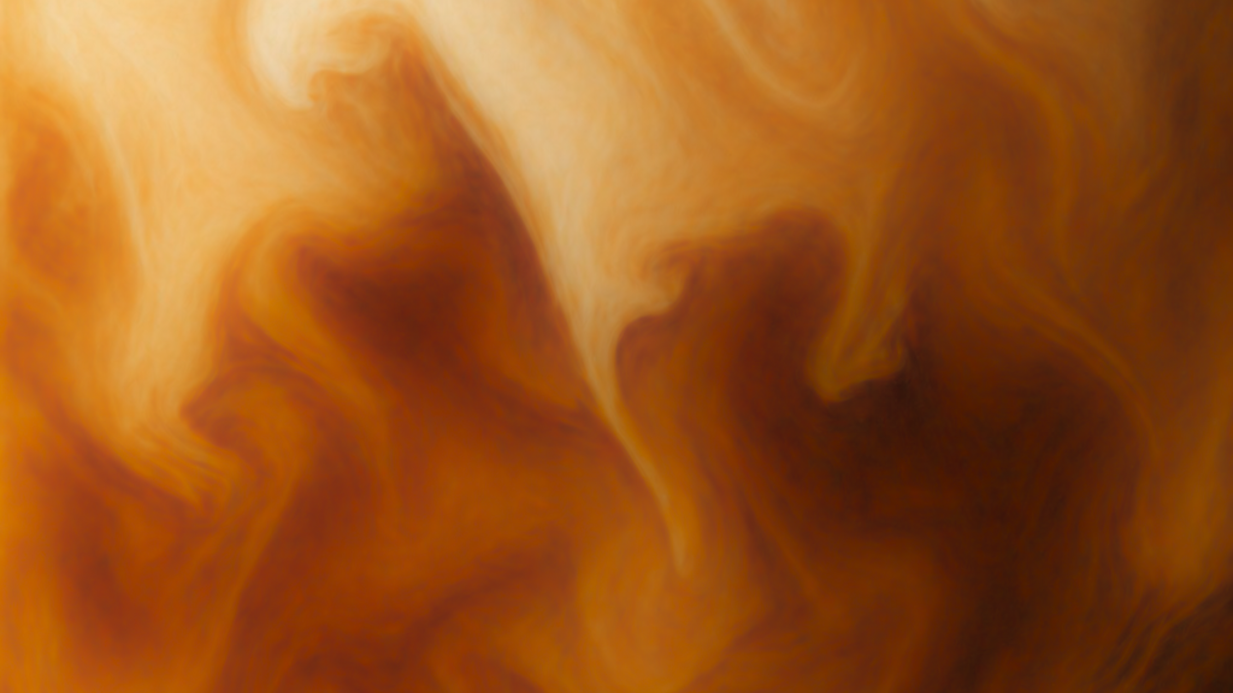 Abstract swirl of milk mixing with coffee.