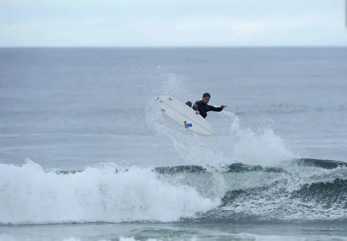 A person surfing on a surfboard in the ocean during daytime.